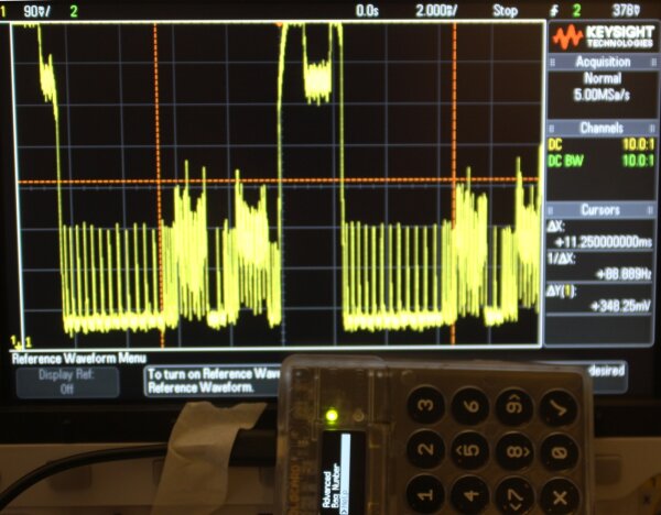Oscilloscope view with Coldcard Mk1 in the foreground.