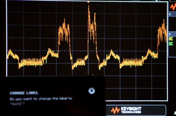 Oscilloscope view with KeepKey in the foreground.<br/> The first bump in the trace is caused by <code>CHANGE LABEL</code>, the second by <code>do you want to change the label to</code>.